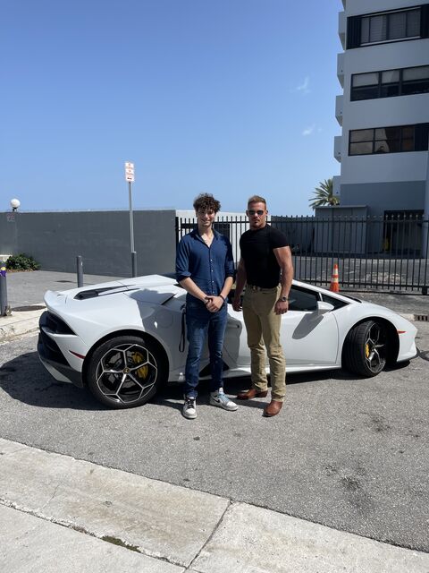 Tristan Gross posing with a friend and a sports car