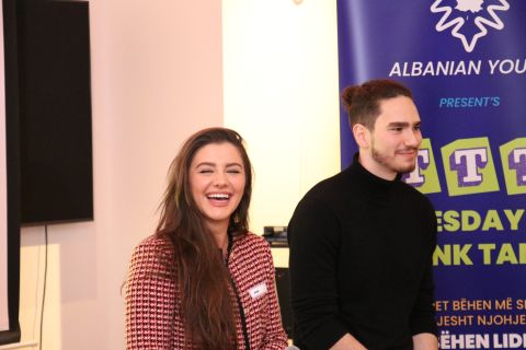 Tristan Gross laughing with a fellow speaker at a community panel event