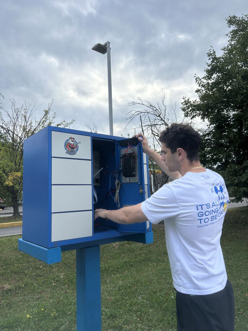 Tristan Gross installing and wiring a TRIZAN smart locker on location