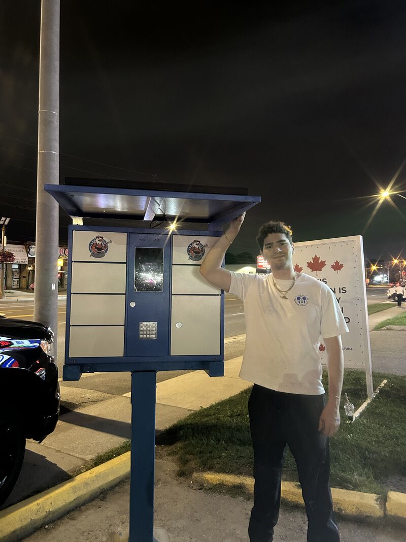 Tristan Gross next to a deployed TRIZAN smart locker at night